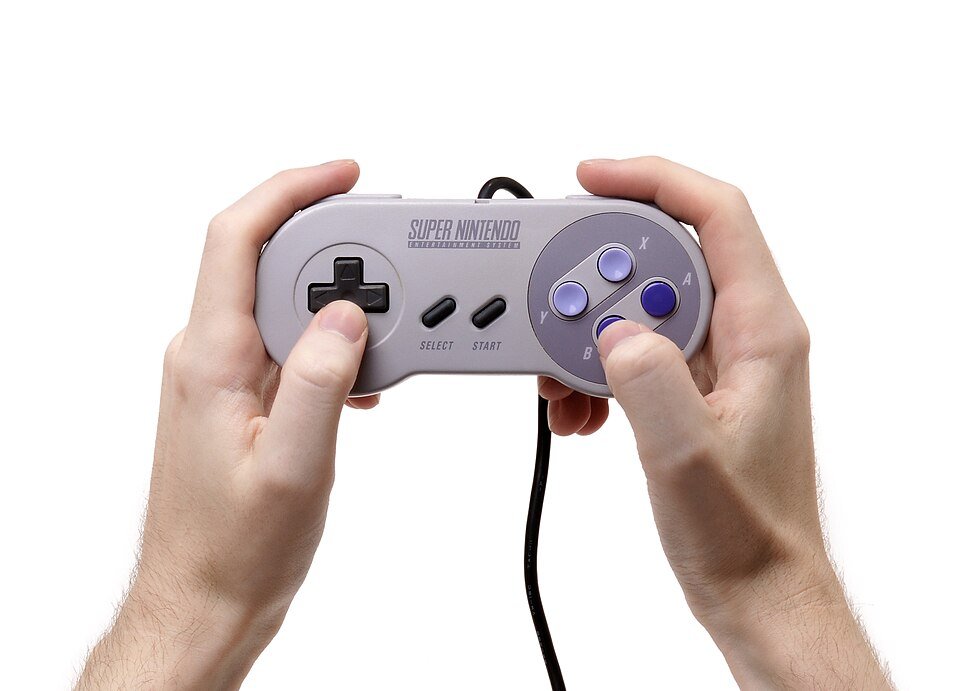 A classic Super Nintendo controller held in two hands, showing the D-pad and four-button layout