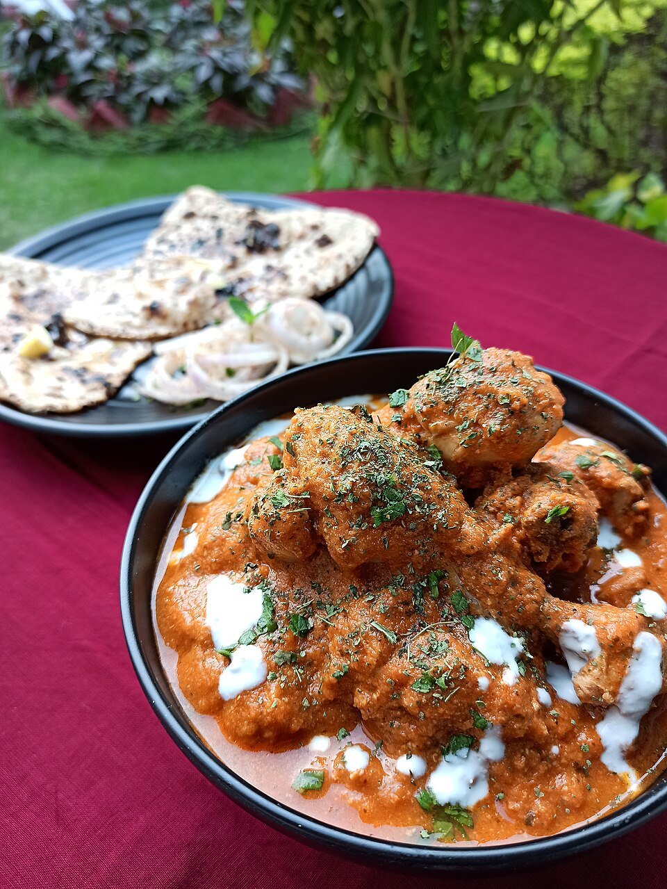 A rich Indian chicken curry served with naan bread, an example of gourmet chicken from India
