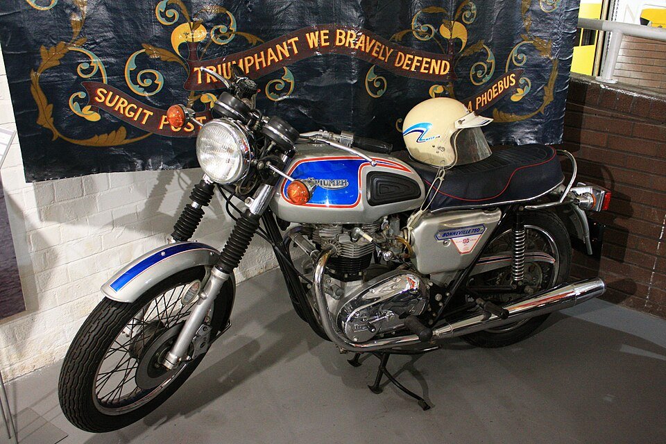 Classic silver and blue Triumph Bonneville T140 motorcycle on display in a British motorcycle museum