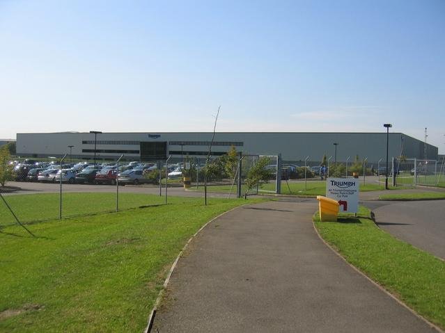Exterior of the modern Triumph Motorcycles factory building in Hinckley, Leicestershire, with car park and Triumph signage