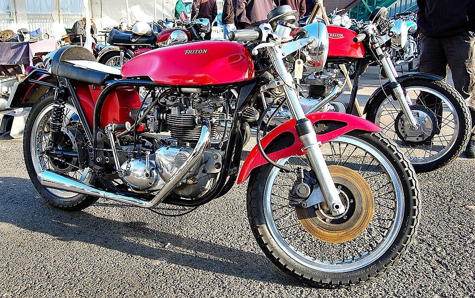 A red Triton cafe racer special combining a Triumph twin engine with a Norton Featherbed frame, at a British motorcycle show