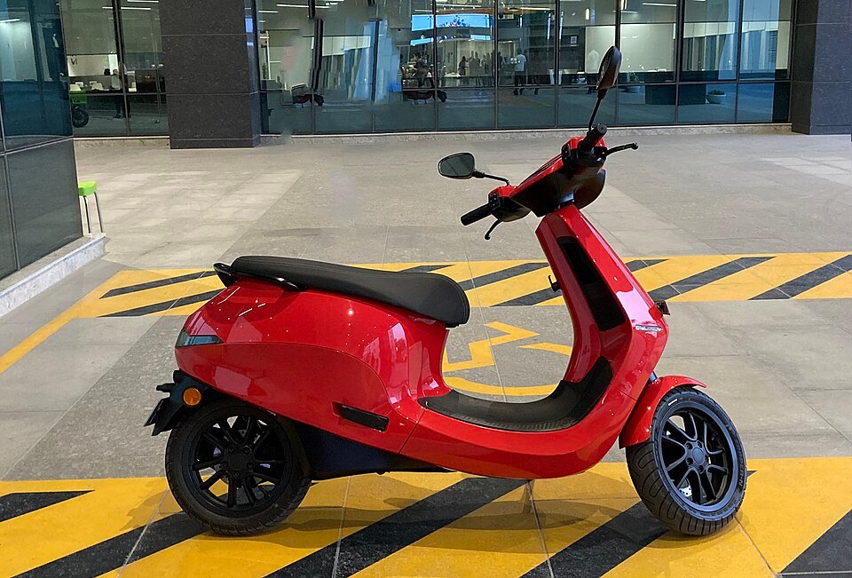Electric scooter parked outside a company facility in India, representing the current generation of Indian EV two-wheelers