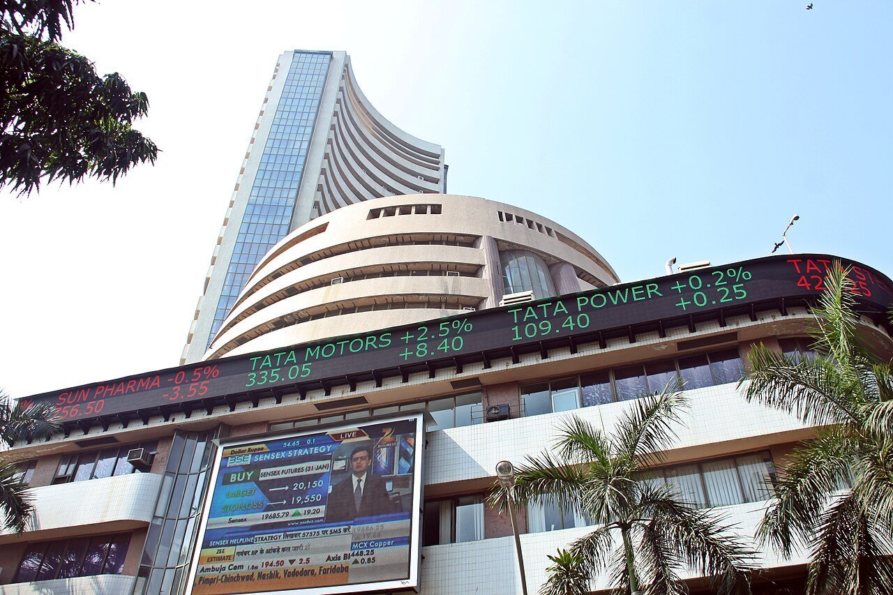 The BSE building on Dalal Street with a scrolling stock ticker and palm trees in front