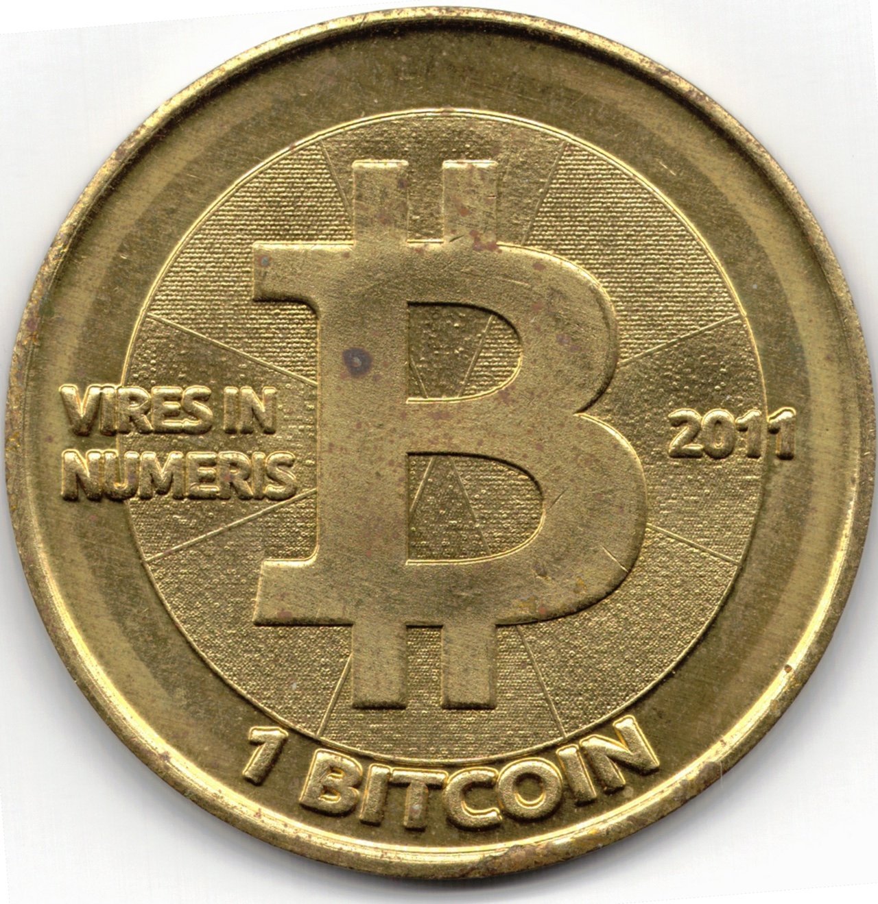 Brass-coloured 2011 Casascius physical bitcoin token with a large B symbol and the words Vires in Numeris