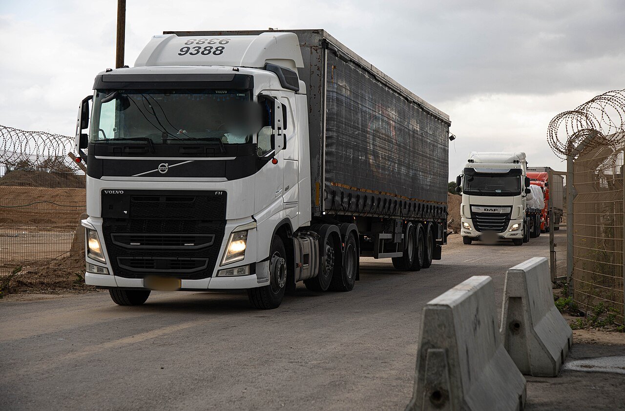 Trucks carrying humanitarian aid pass a checkpoint at the Zikim crossing into northern Gaza on 25 November 2025, after the October ceasefire