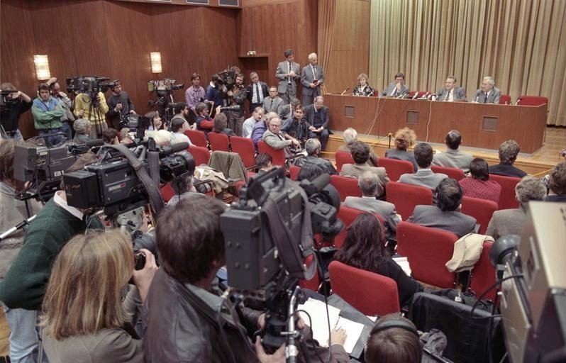 Press conference hall in East Berlin on 9 November 1989 with camera crews in the foreground and officials seated at a long table