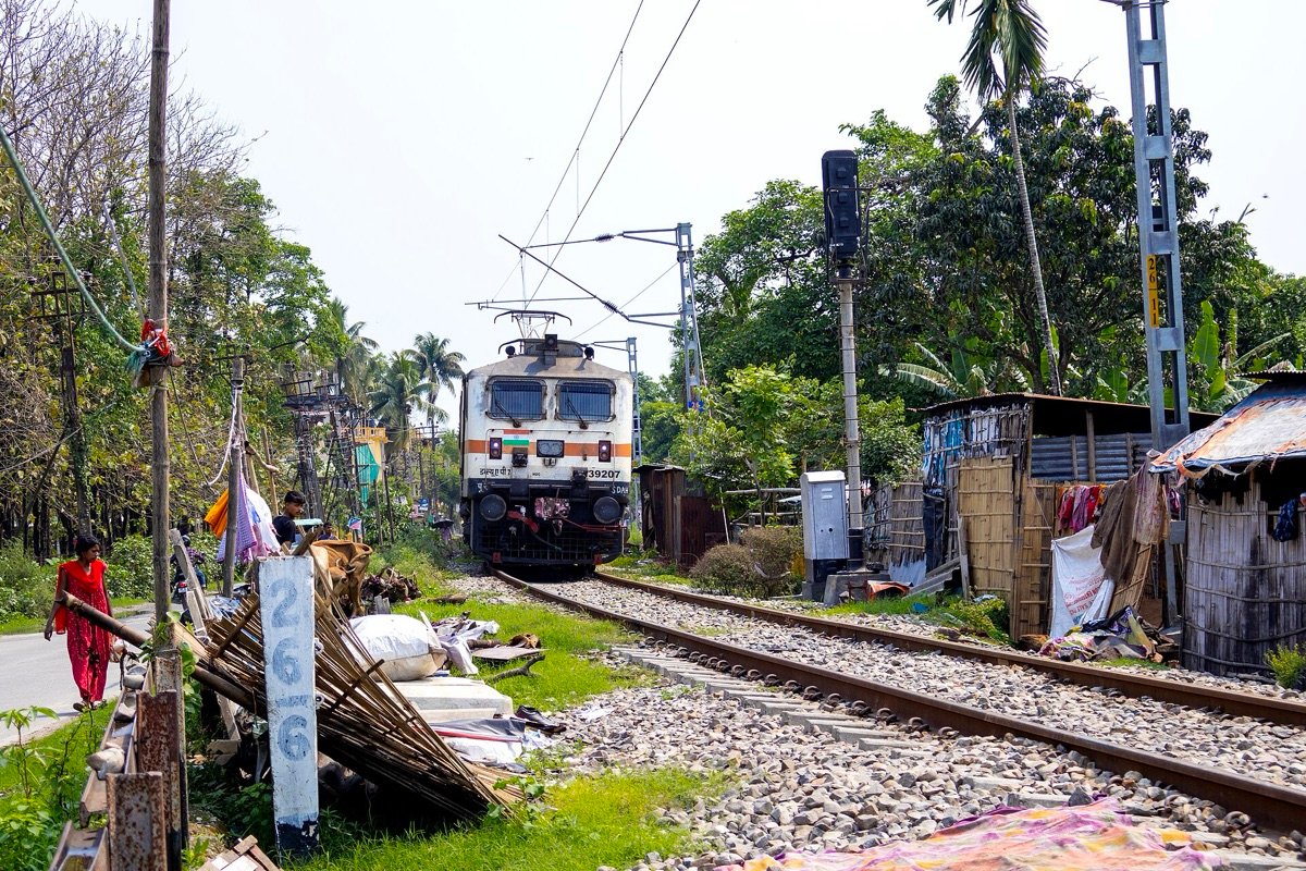 A WAP-7 electric locomotive hauls the Sealdah–Bamanhat Uttar Banga Express in West Bengal in April 2025